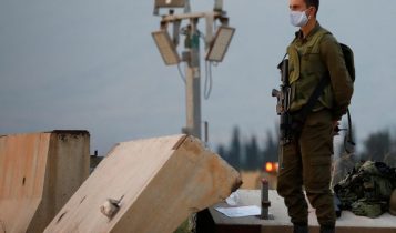 Israeli soldier stands guard next to an Iron Dome anti-missile system near the Israel's northern border